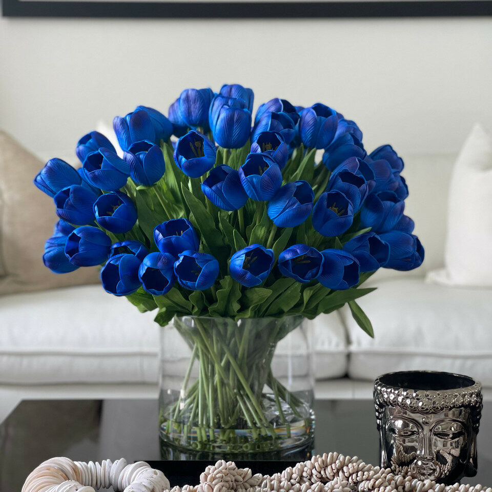 Blaue Tulpenarrangements in großer zylindrischer Vase