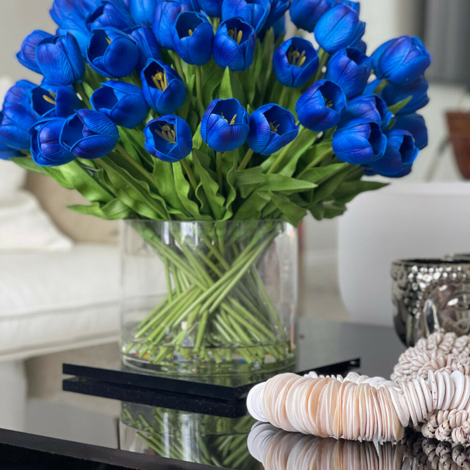 Blaue Tulpenarrangements in großer zylindrischer Vase